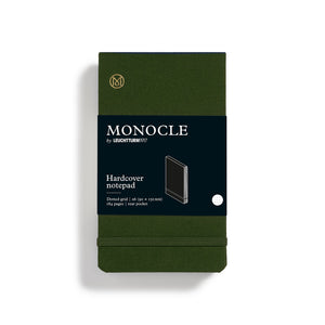Green Monocle notebook with black label on a white background