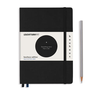 Black notebook with Bauhaus edition label and a pencil on a white background