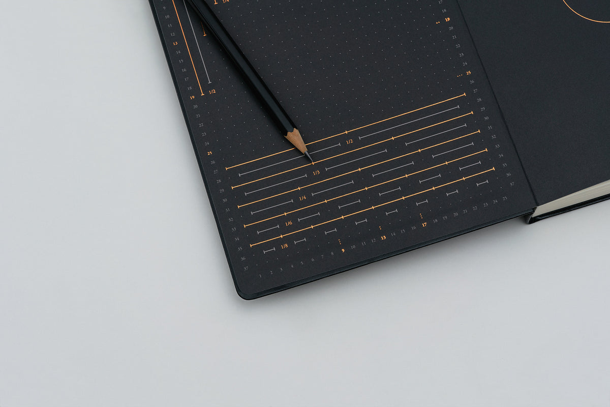 Black notebook with gold accents on a light gray background