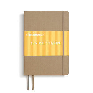Notebook with beige cover and yellow striped design on a white background