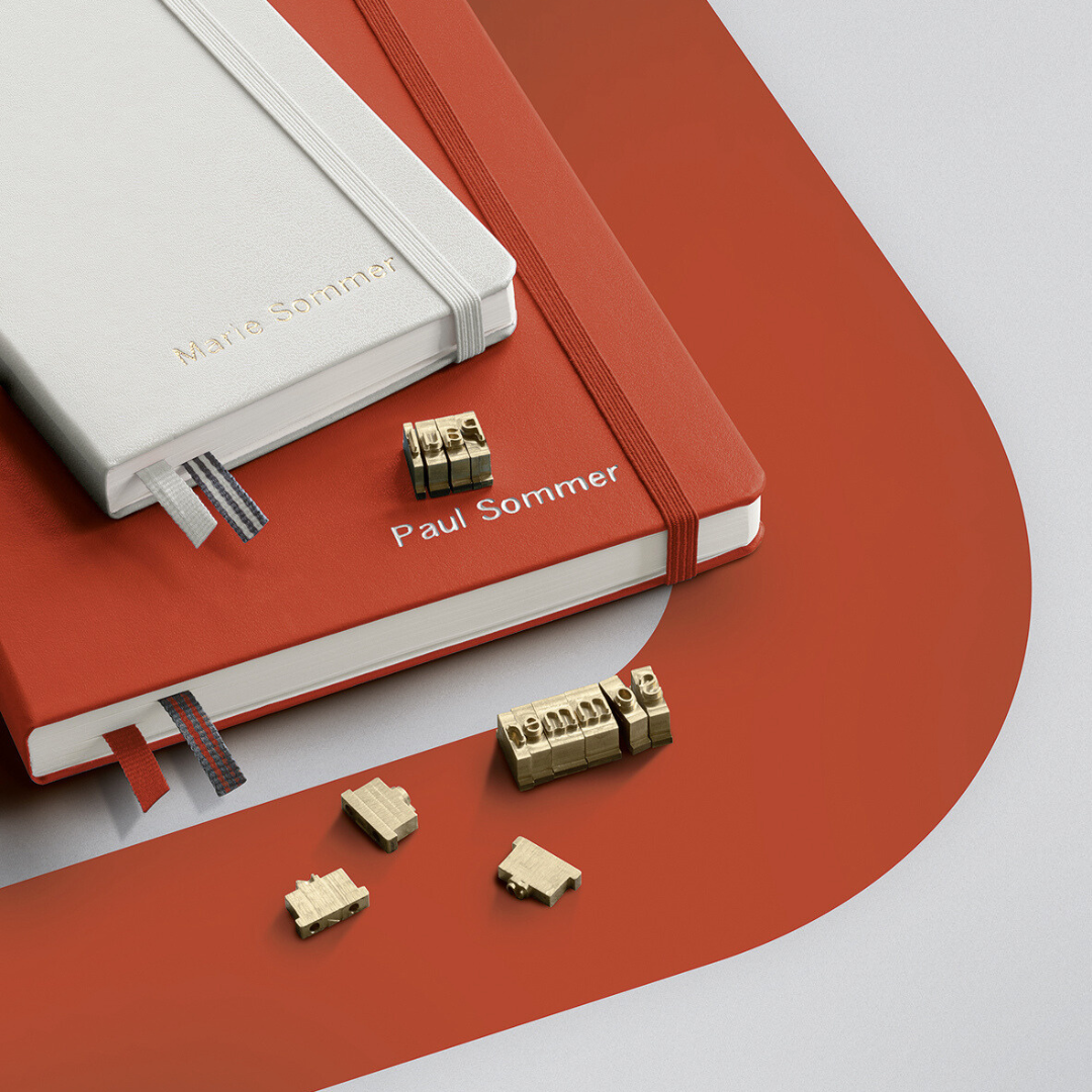 Red notebook with gold engraving stamps on a white background