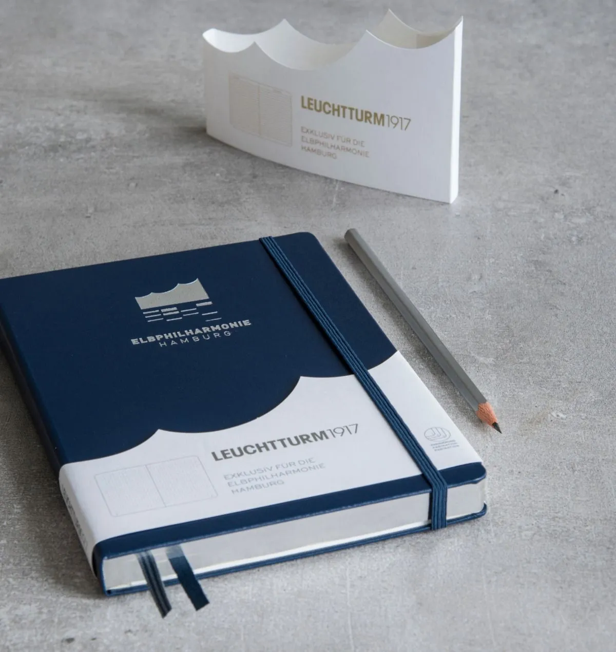 Leuchtturm1917 notebook with a pencil on a gray surface