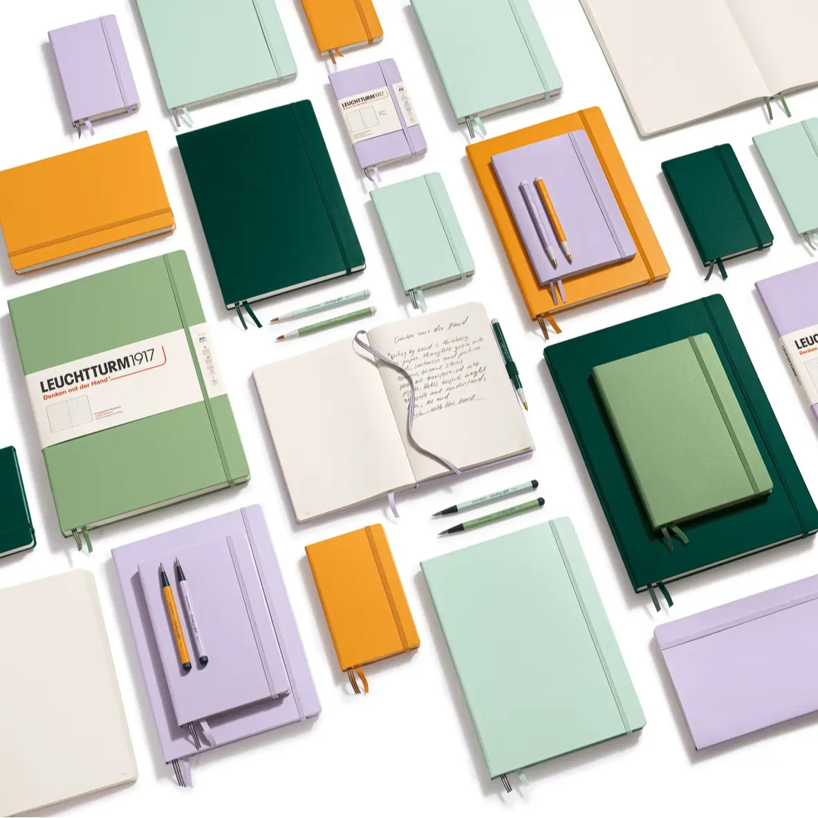 Collection of colorful notebooks and pens on a white background