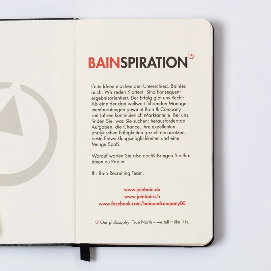 Open notebook with Bain & Company branding and text on a white background