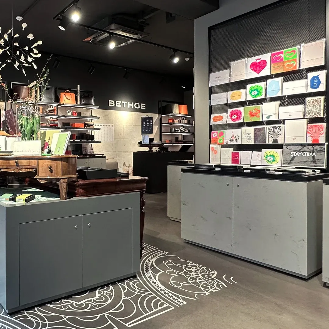 Store interior with a display of colorful greeting cards and a 'Bethge' sign.