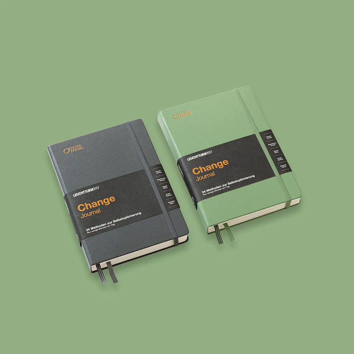 Two journals, one black and one green, on a green background