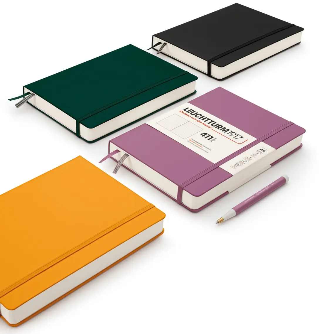 Four notebooks in different colors with a pen on a white background