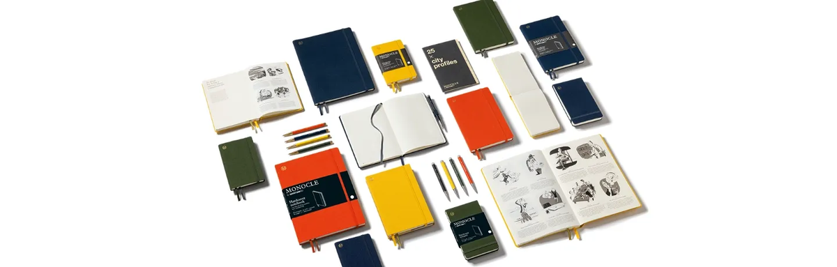 Collection of colorful notebooks and stationery items on a white background