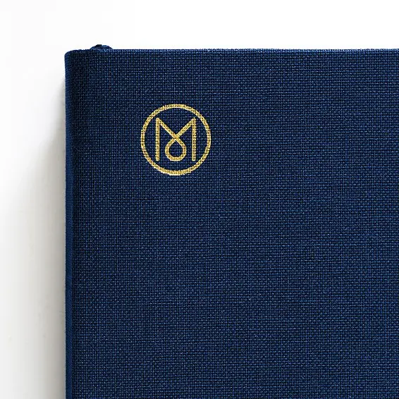 Navy blue book with a gold emblem on a white background