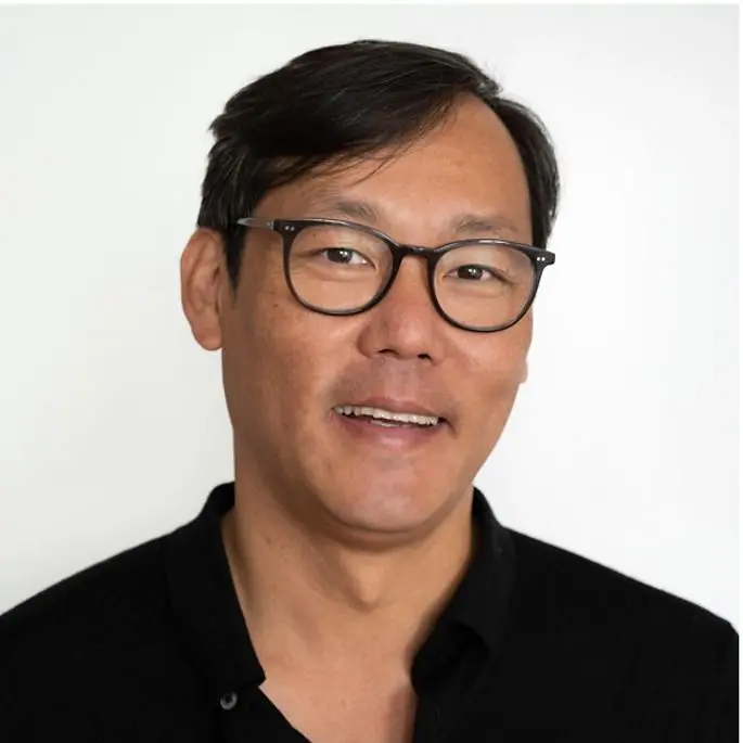 Man wearing glasses and a black shirt against a white background