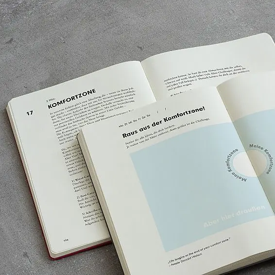 Open book with text and a cover featuring a blue gradient on a gray surface
