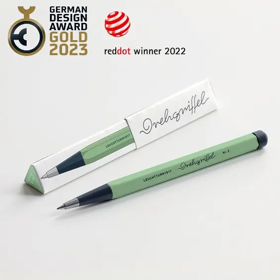 Green pen with black cap on a white background, featuring German Design Award and Red Dot Award logos.