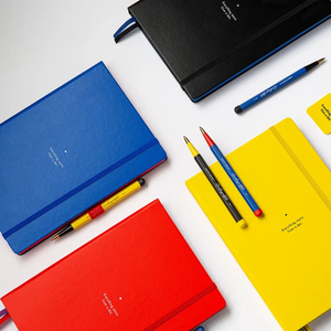Colorful notebooks and pens on a white background