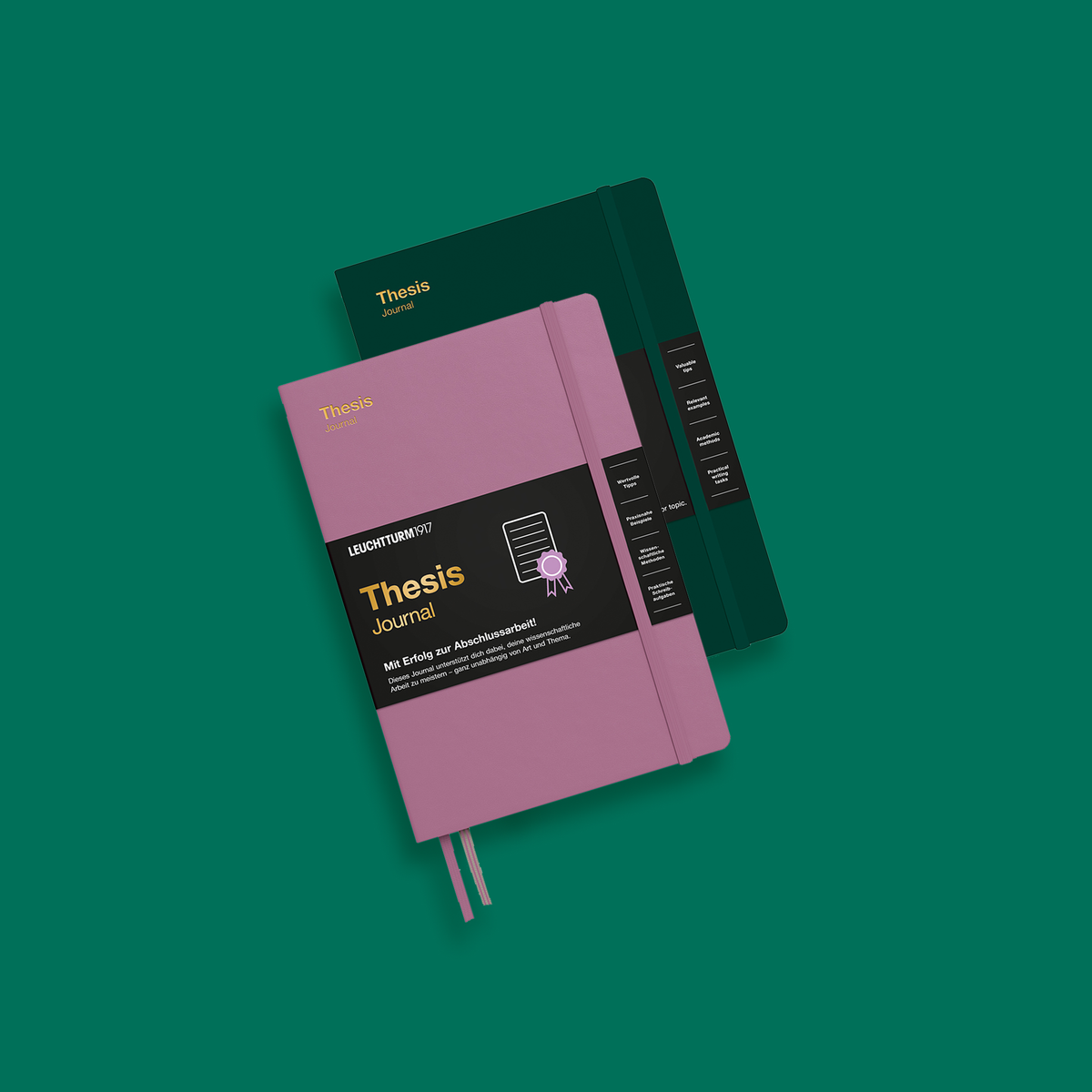 Two Leuchtturm1917 thesis journals, one pink and one black, on a teal background.