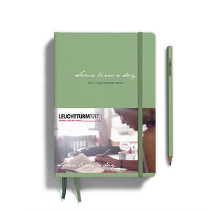 Green notebook with a pen on a white background