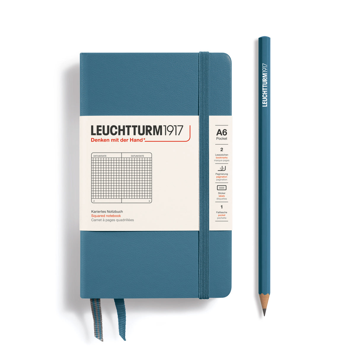 Blue notebook with white label and matching pencil on a white background