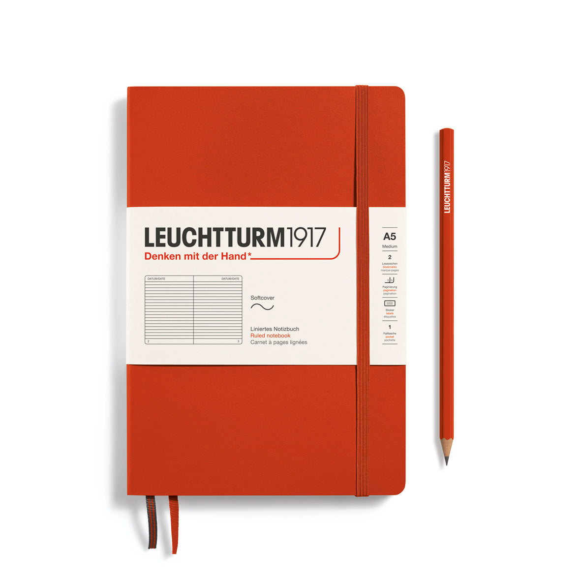 Red notebook with Leuchtturm1917 branding and a pencil on a white background