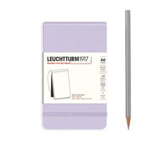 Purple notebook with Leuchtturm1917 branding and a pencil on a white background