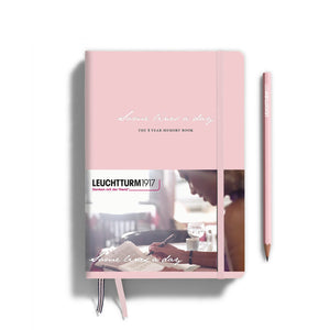 Pink notebook with a pencil on a white background