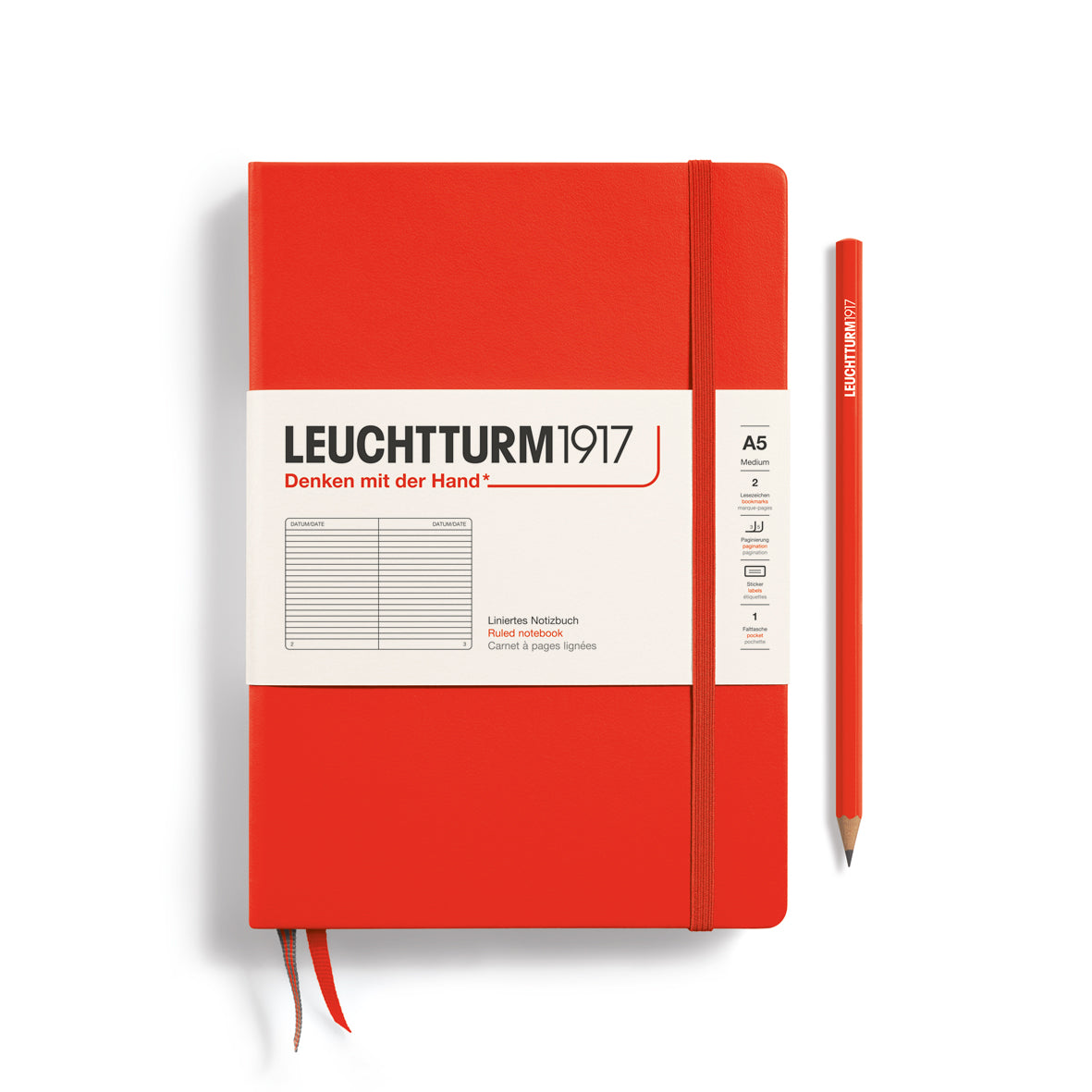 Red notebook with Leuchtturm1917 branding and a pen on a white background