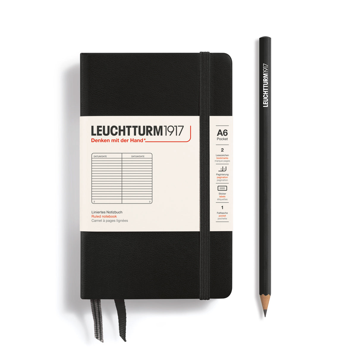 Black notebook with white label and matching pencil on a white background