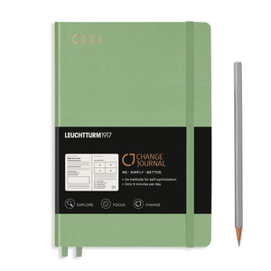 Green notebook with black label and pencil on a white background
