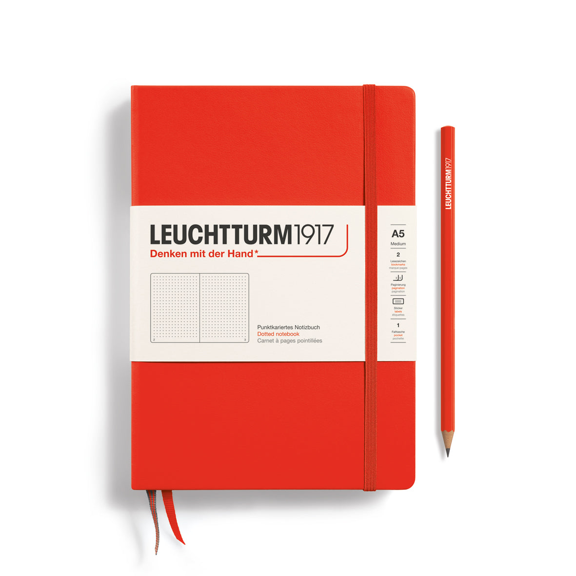 Red notebook with Leuchtturm1917 branding and a pen on a white background