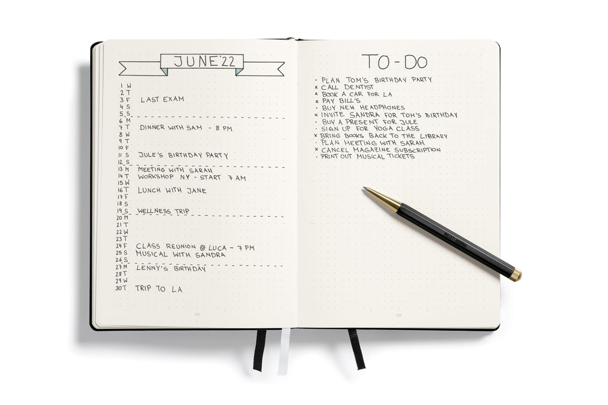 Open notebook with a to-do list and calendar on June 22nd, featuring a pen on a white background.