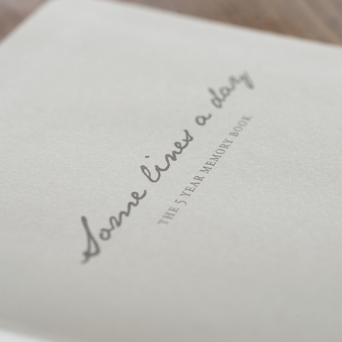 White book with 'Some lives a day' text on a light background