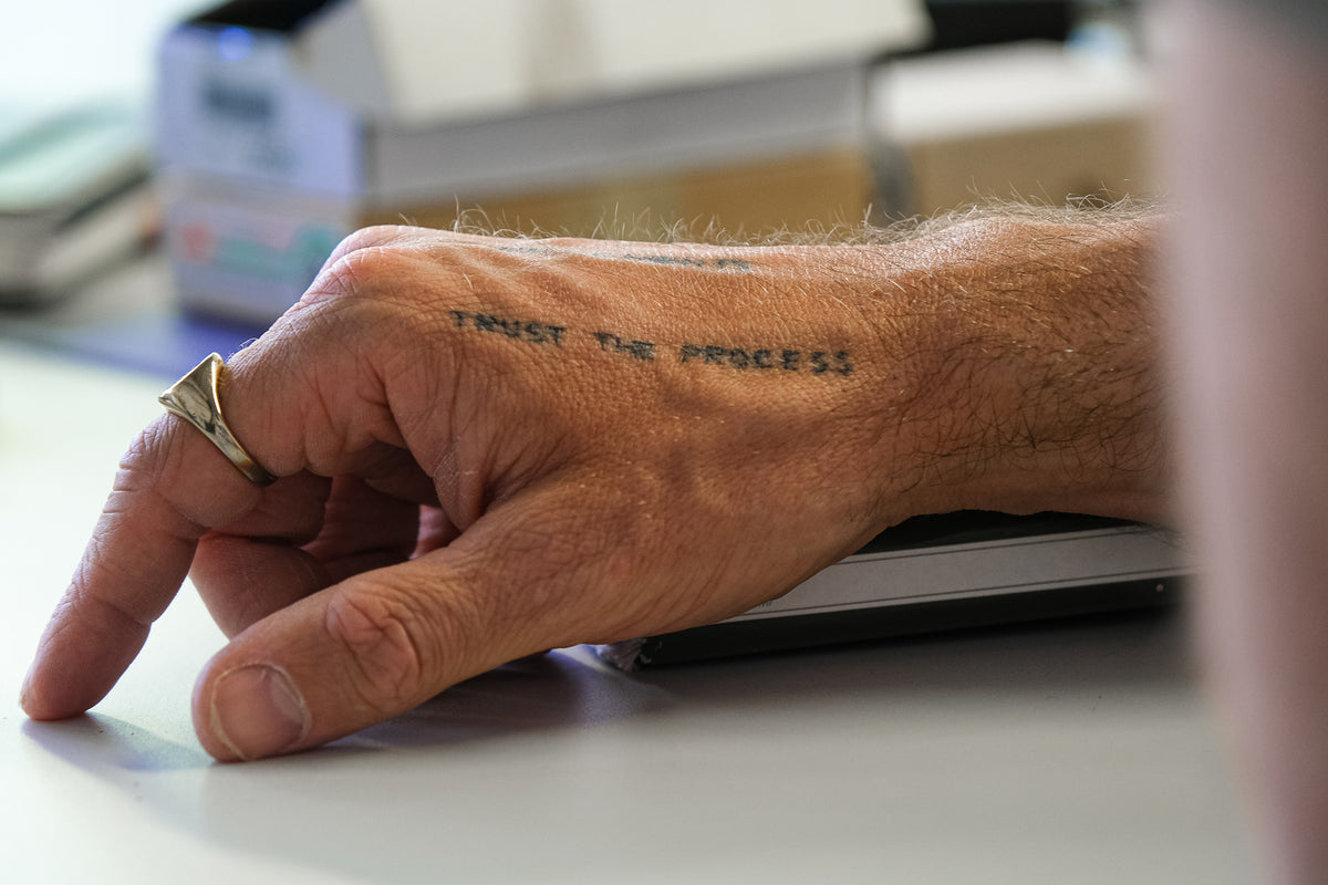 Hand with 'Trust the Process' tattoo