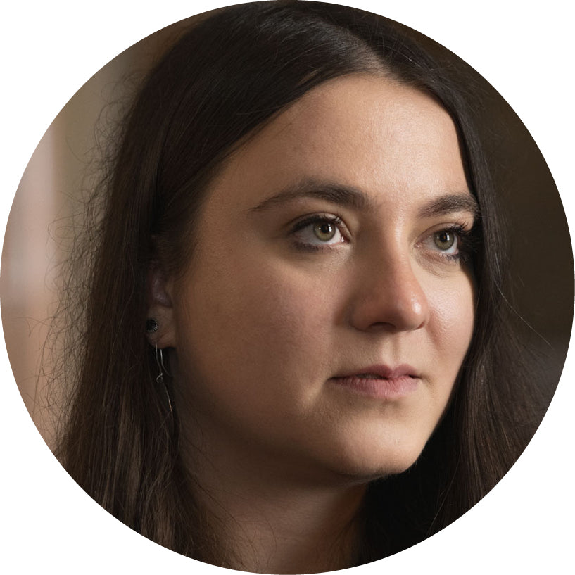 Round cropped photo of a woman with dark hair on a plain background