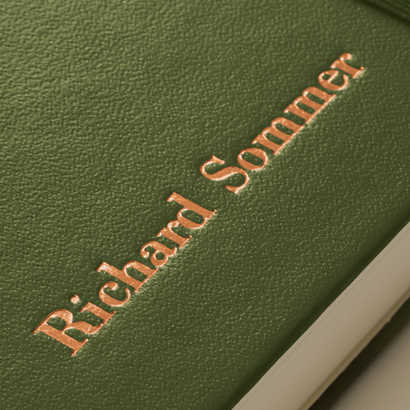 Green leather-bound book with embossed name on the cover