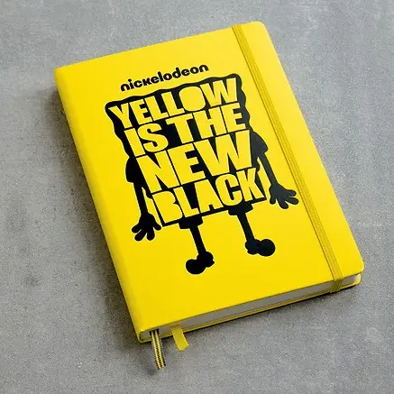 Yellow notebook with 'Yellow is the New Black' text and Nickelodeon logo on a gray background