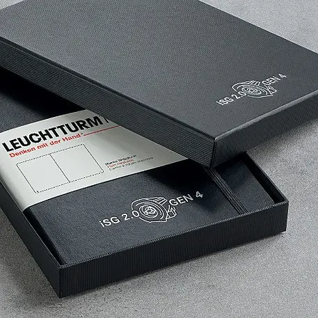 Black leather-bound notebook with embossed logo on a gray surface