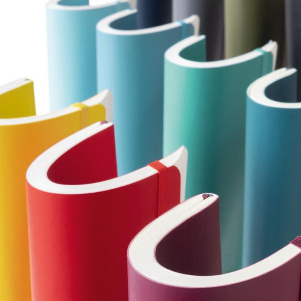 Colorful folded notebooks in various colors on a white background