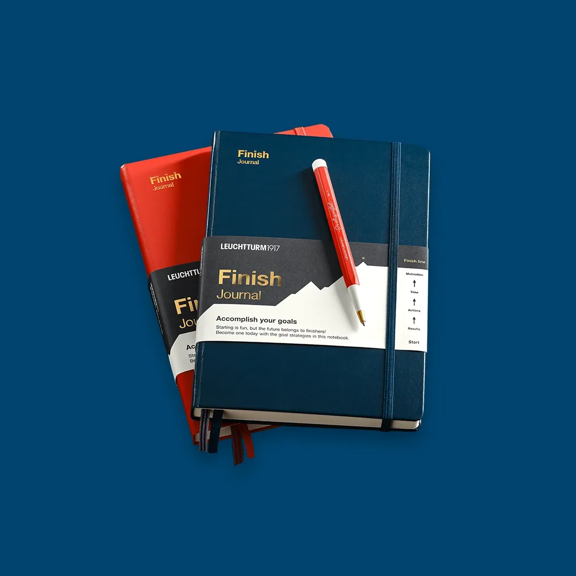 Set of Leuchtturm1917 finish journals with a pen on a blue background