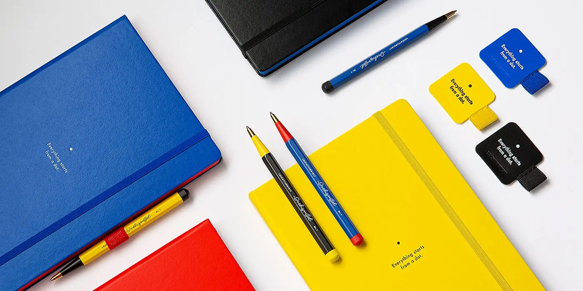 Assorted stationery items including notebooks, pens, and markers on a white background
