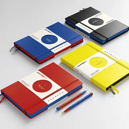 Four colorful notebooks with matching pen on a light gray background