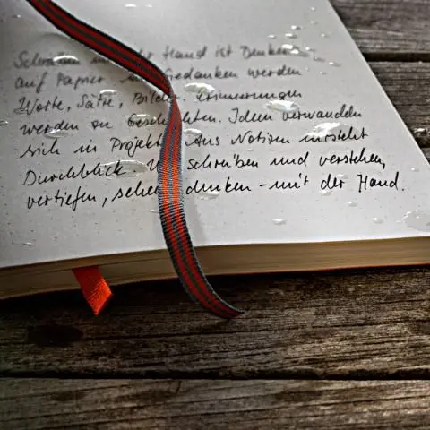 Open book with handwritten text on a wooden surface