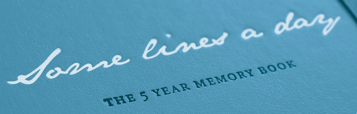 Blue memory book with 'Some lines a day' and 'The 5 Year Memory Book' text.