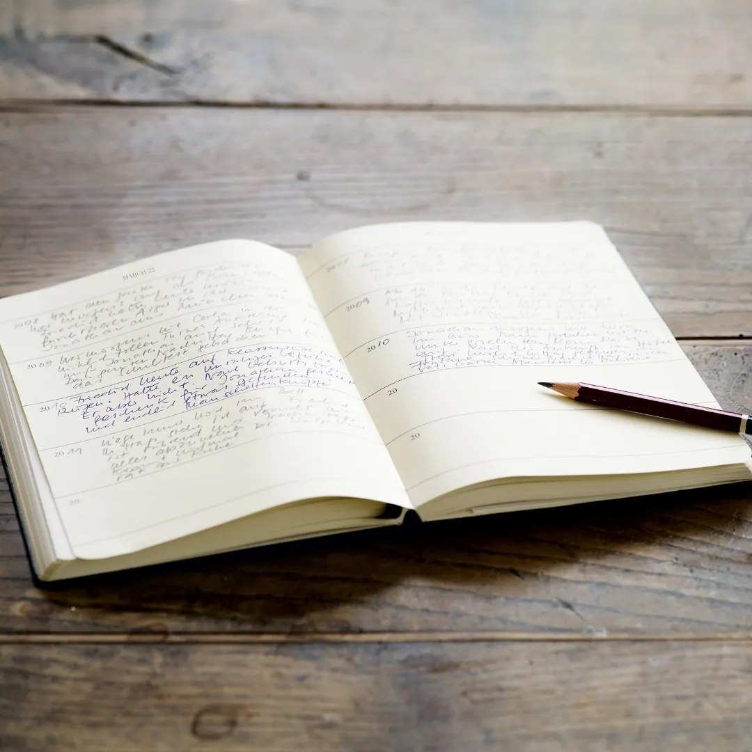Open notebook with handwritten text on a wooden surface