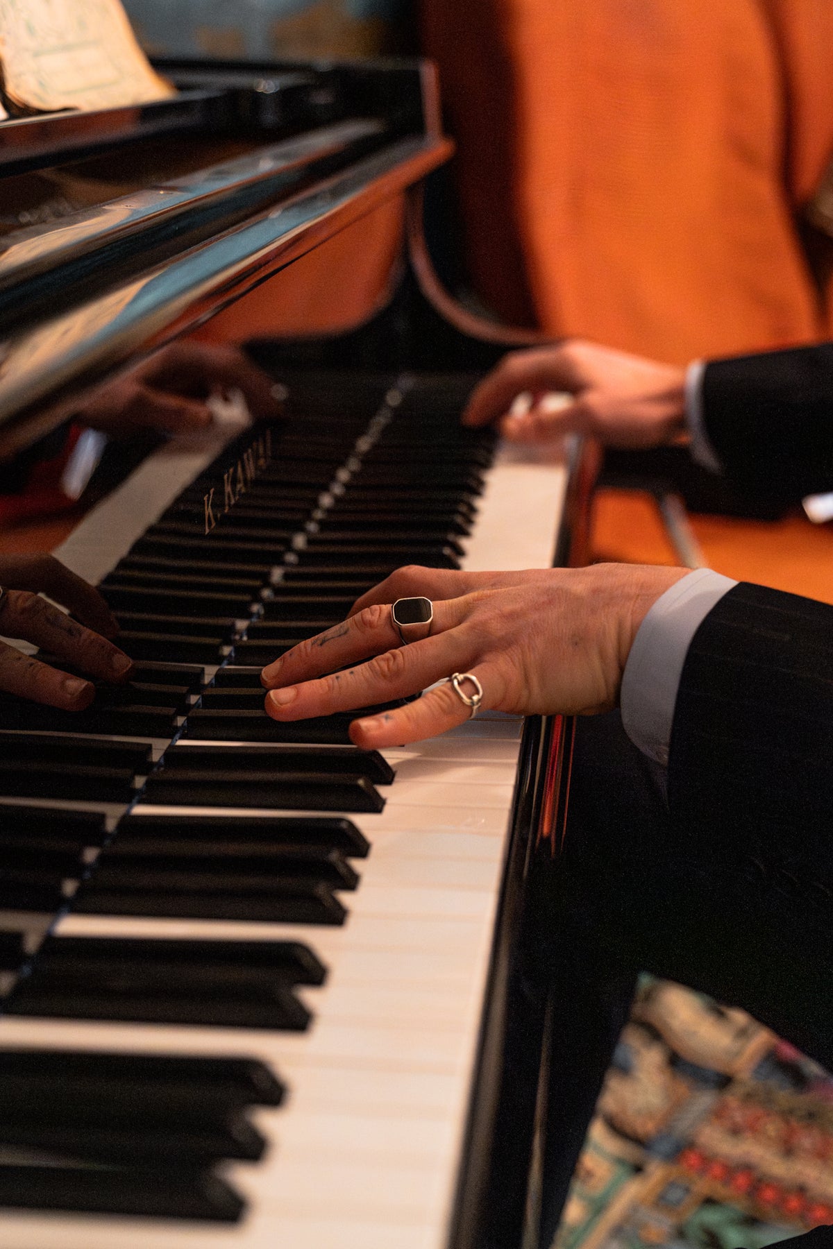 Close-up of hands playing a piano with a blurred background