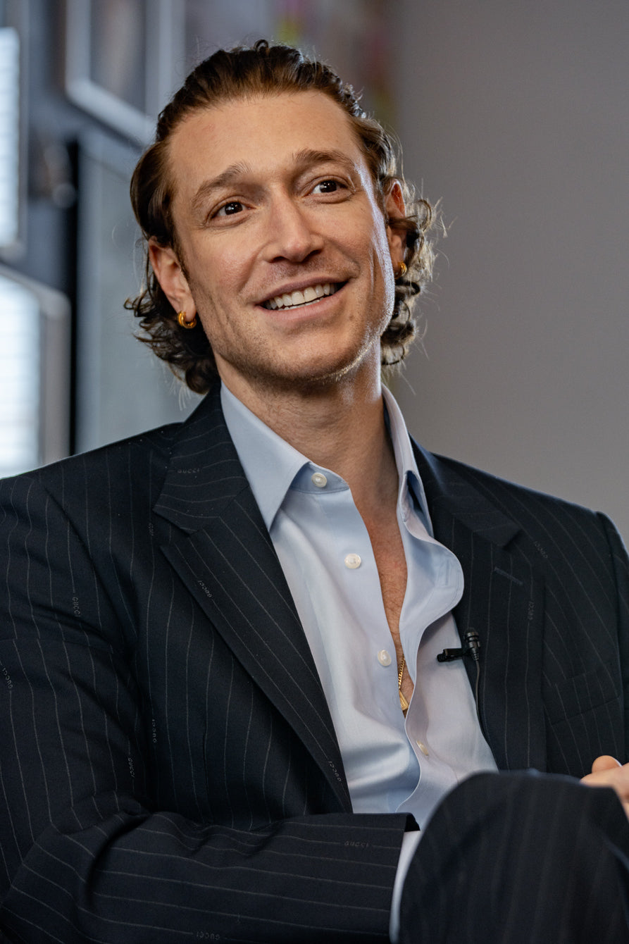 Man in a suit smiling in an indoor setting