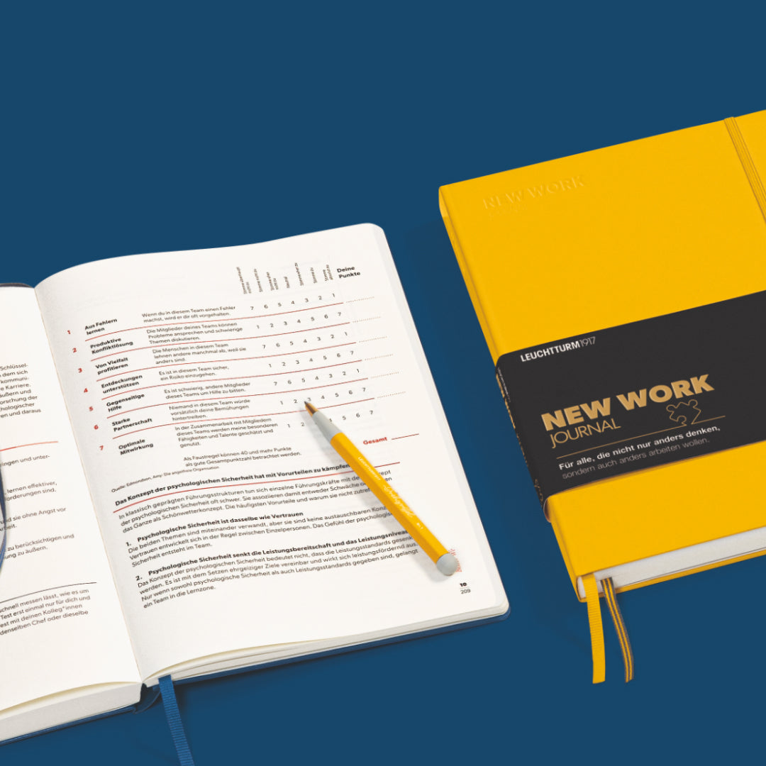 Open notebook with a yellow pen on a blue background, featuring the Leuchtturm1917 brand.