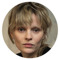 Close-up of a person with short hair, wearing a black top.
