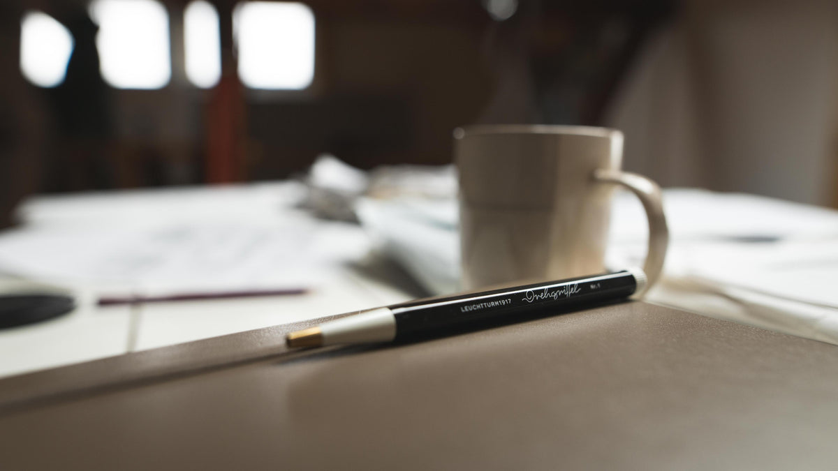 Pen and mug on a table with a blurred background