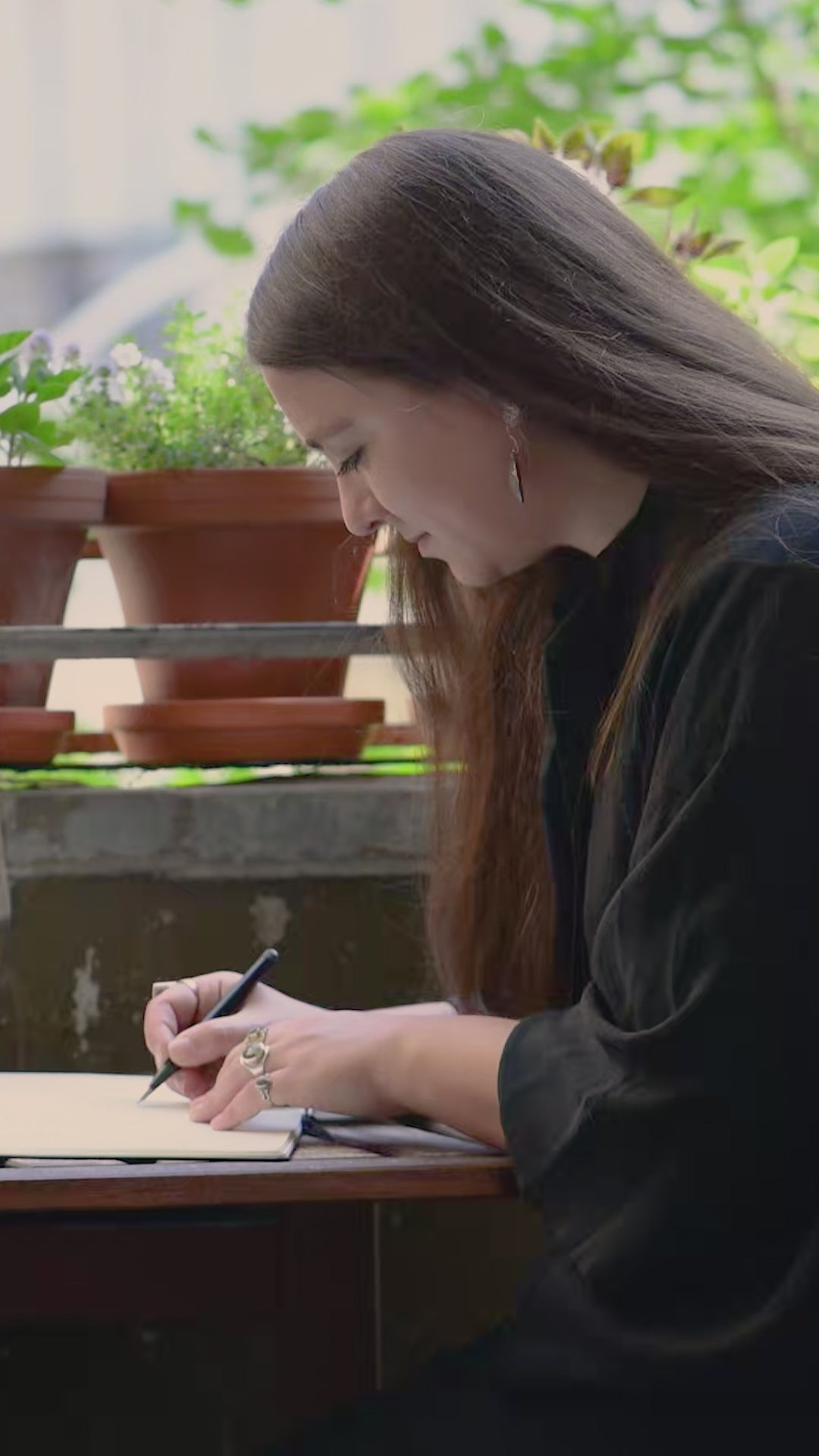 Video featuring a composer writing music in notebook and speaking about her process