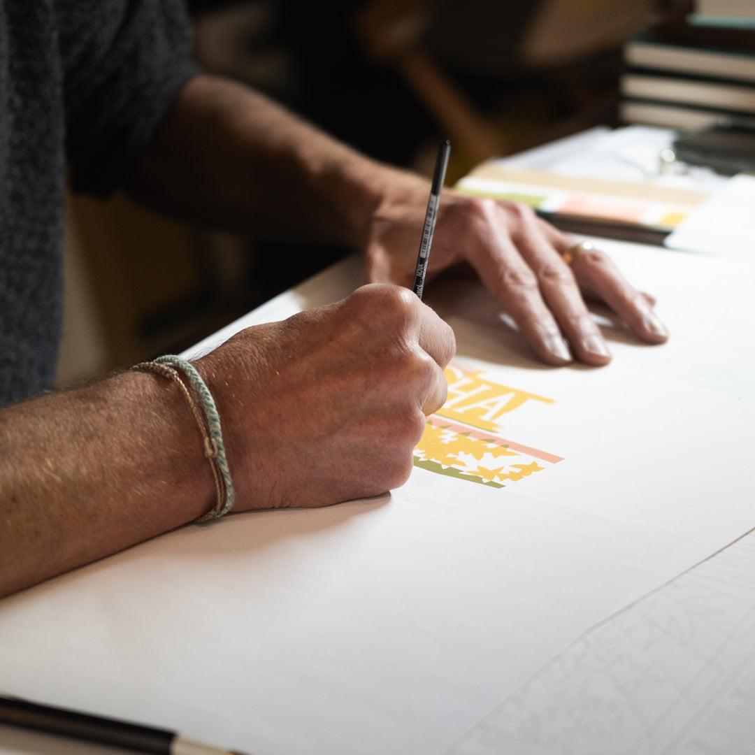 Person drawing on a piece of paper with a pencil