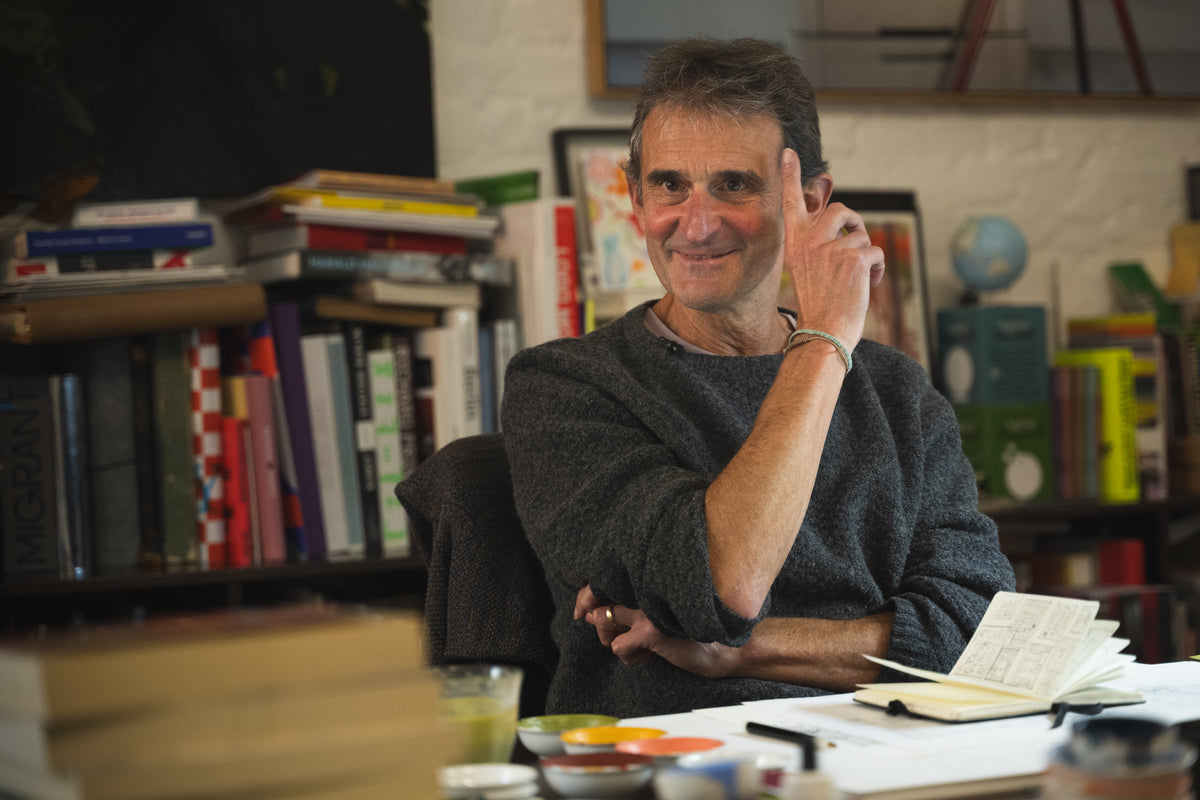 Man sitting in a room with books and papers around him
